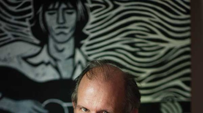 John Milward in front of an illustration of Keith Richards by Margie Greve