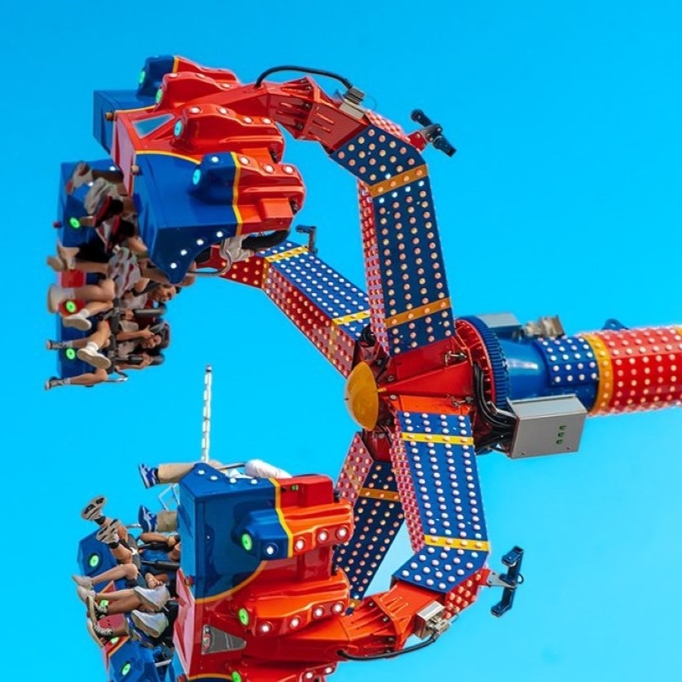 The carnival midway features thrill rides like the Superman.