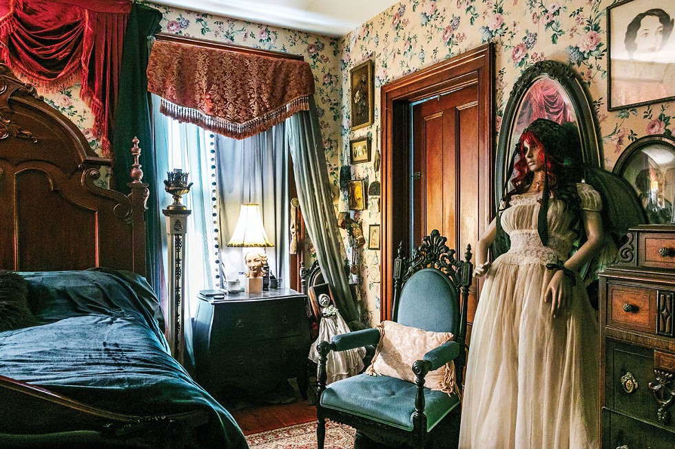 The primary bedroom of Julia Drahos’s Victorian sits on the second floor. Drahos decorated the space with antiques, oddities, and gothic flair that match her love of “all things creepy.” “My aesthetic is Addams Family,” she says. “The mannequin reminds me of my favorite Vincent Price movie, House of Wax. I love classic old movies. “